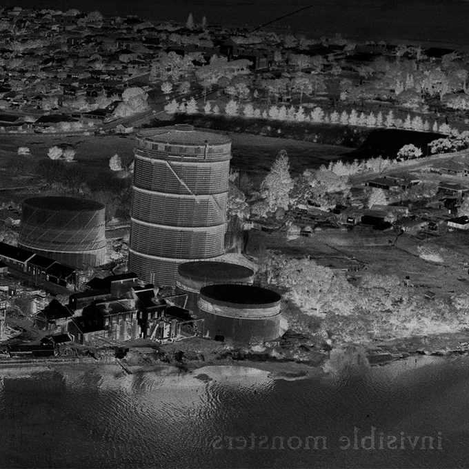black and white negative image with a gasometer. Faint text lower right hand corner printed mirror reversed: invisible monsters