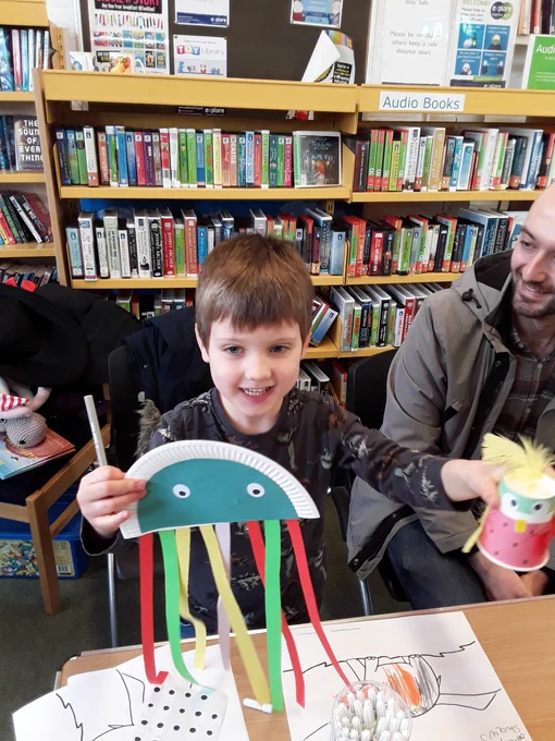 Child holding paper plate octopus craft