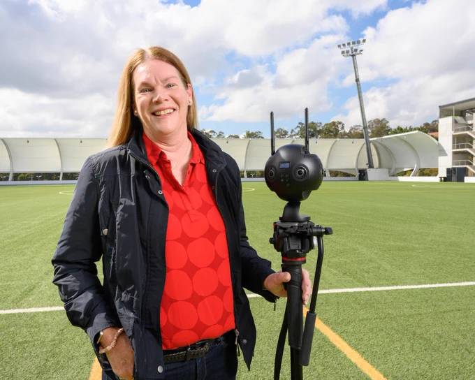 Dr Katherine O'Brien with a 360 camera on QUT Sport field