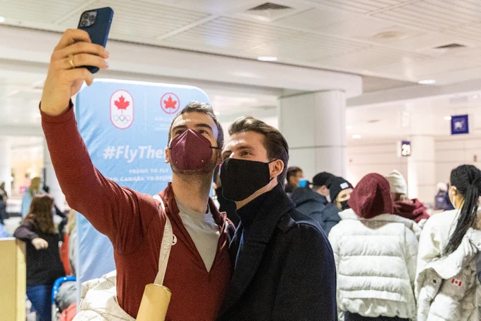 A Canadian athlete poses for a selfie with a fan.
