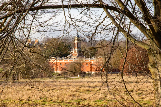 Wimpole seen through the branches of a wintry tree.