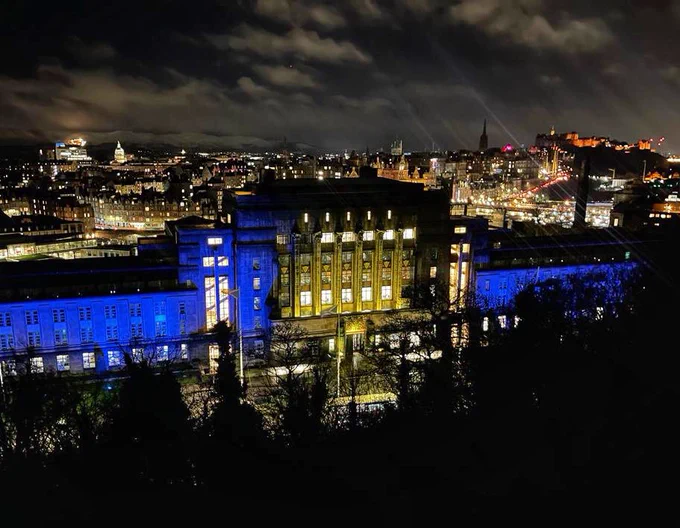 St Andrew's House, Edinburgh, lit up in blue and yellow.
