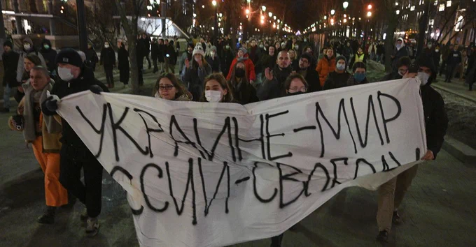 Demonstrators march with a banner that reads "Ukraine—Peace, Russia—Freedom," in Moscow on February 24, 2022, after Russia's attack on Ukraine.
