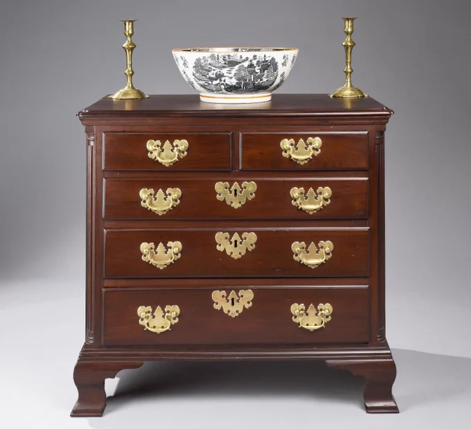 Excellent example of a Philadelphia low chest in a desirable small size. Overhanging top with notched corners, two over three drawer arrangement, fluted quarter columns and resting on ogee feet. Image courtesy of H L Chalfant American Fine Art & Antiques.


https://www.incollect.com/articles/the-philadelphia-show-turns-60-years-old-in-style-with-glamorous-new-venue