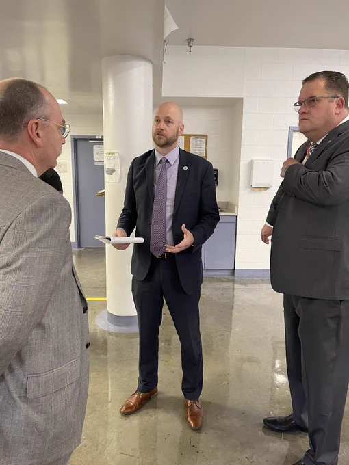 Commissioner Turner speaking with two men inside room at the corrections facility