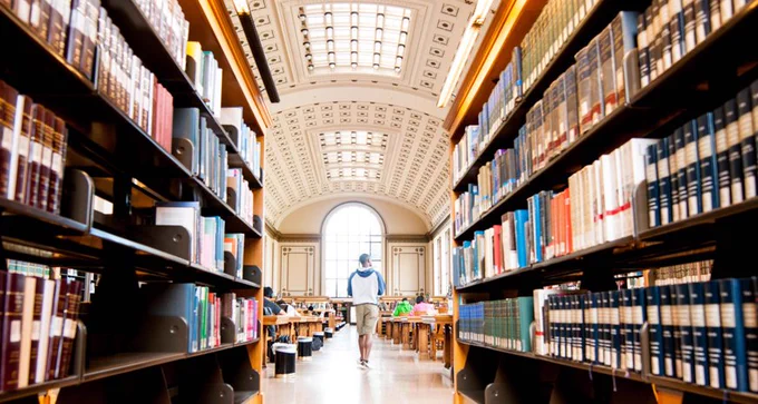 Doe Library’s North Reading Room, with its vaulted ceiling, is framed between two shelves. 