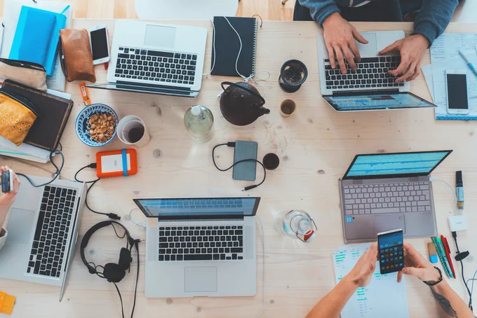 Photo by Marvin Meyer on Unsplash. Group using laptops viewed from above.