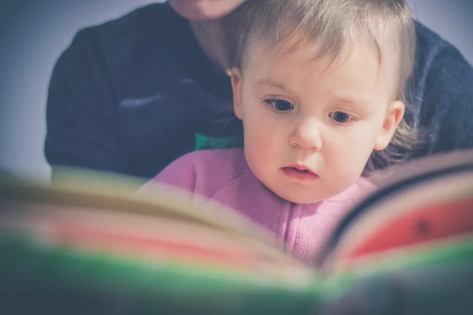 A young child looks at a book