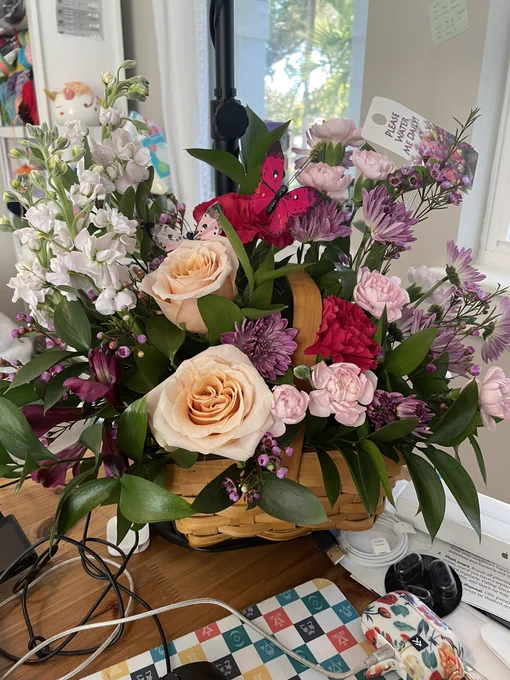 Bouquet of roses and pink flowers in a basket