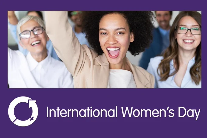Group of women with their arms in the air celebrating International Women's Day 2022.