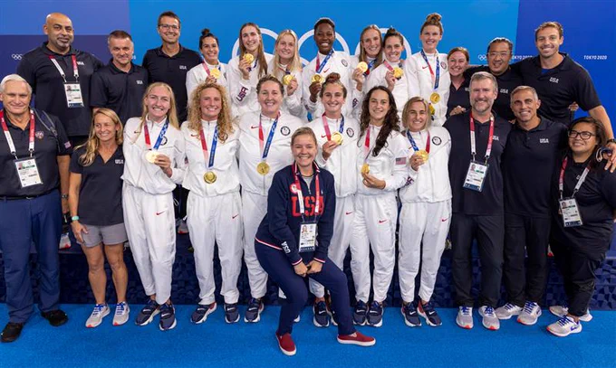USOPC CEO Sarah Hirshland poses for a photo with the women's water polo team after they won gold at the Tokyo 2020 Olympic Games.