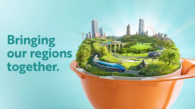 An illustration on a turquoise background featuring several landmark buildings from Yorkshire and Lancashire, surrounded by Pennine countryside together with a TransPennine Express train, a Northern train and a freight train. All of this sits within an orange upturned engineer’s hard hat.