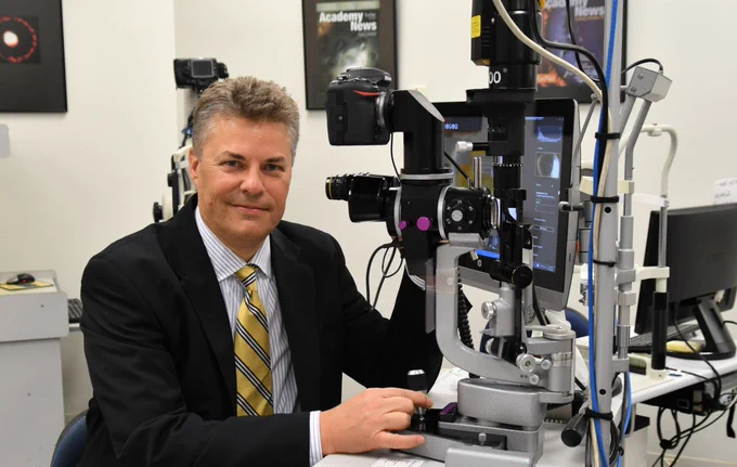 Head of ophthalmology at Flinders University, Professor Jamie Craig in front of some vision testing equipment.