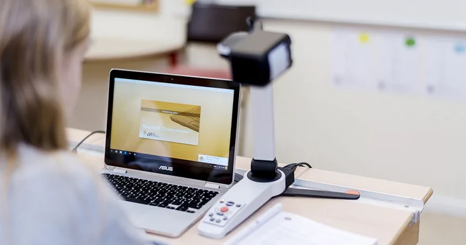 Photo of a student using the ChromeViewer 4.1 on a Chromebook, together with a MagniLink S portable reading camera.