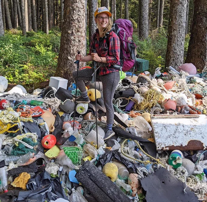 Photo of Hillary on top of a very large pile of trash