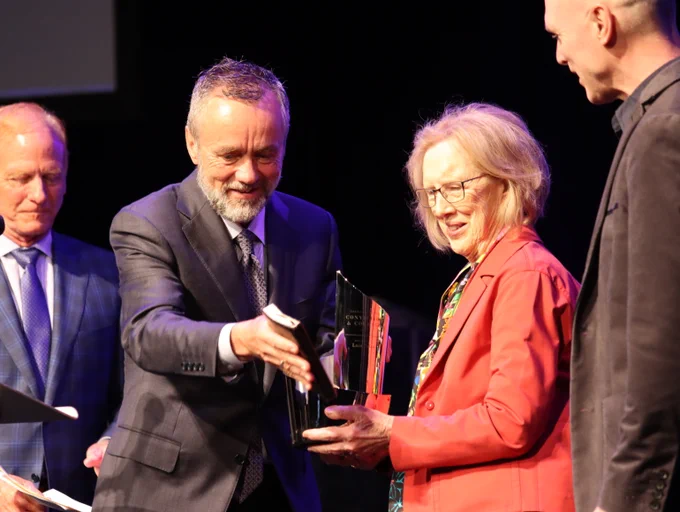 President Corey handing award to Luis Palau's wife and son.