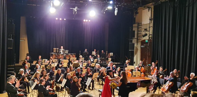 Pianist Hiroko Imai accepts flowers from a girl in front of the Farnborough Symphony Orchestra
