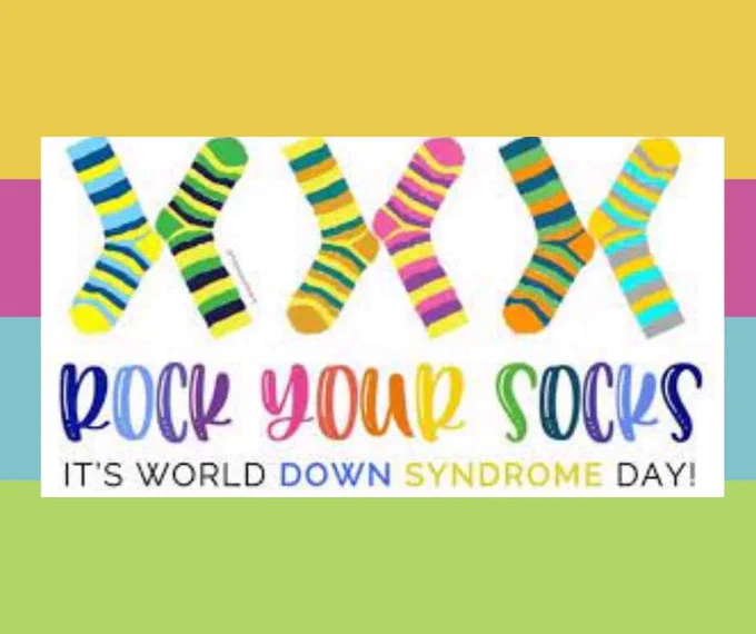 A colorful sign reads rock your socks it's world Down Syndrome Day! The socks are striped and arranged like chromosomes.