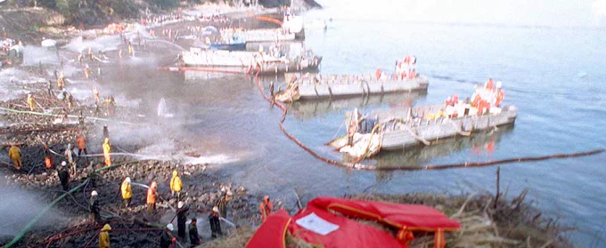 Workers clean up the massive oil spill from the Exxon Valdez after it ran aground in the Gulf of Alaska.