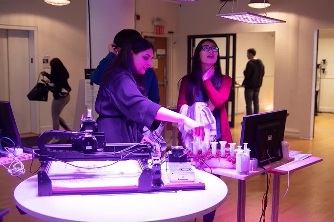 Three people standing around a itp/ima project