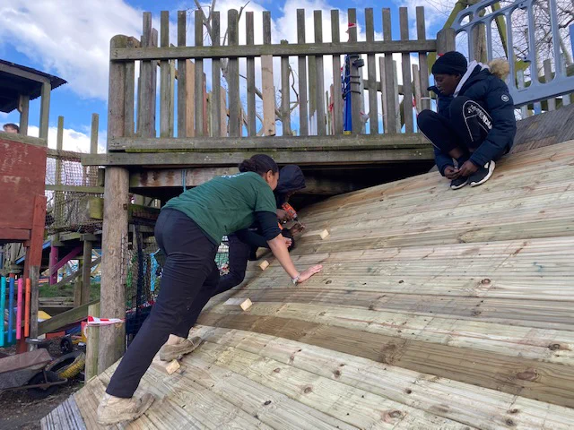 Staff member watches a young person drilling