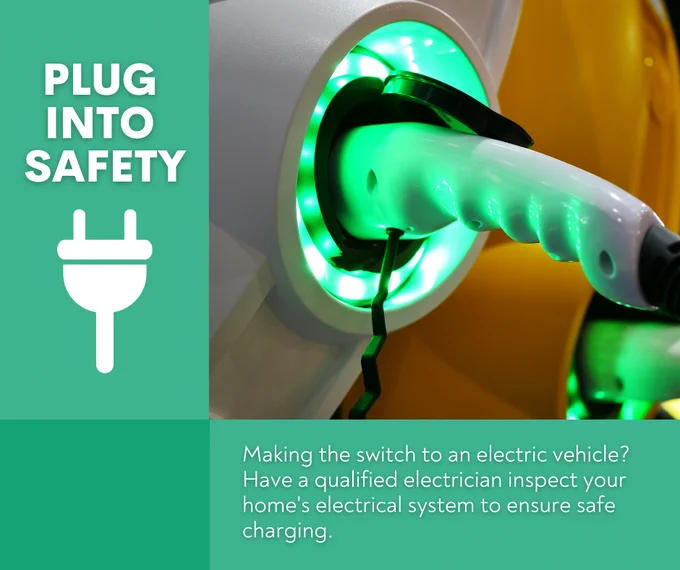 Electric Vehicle plug, plugged into a charge station lit up with green lights