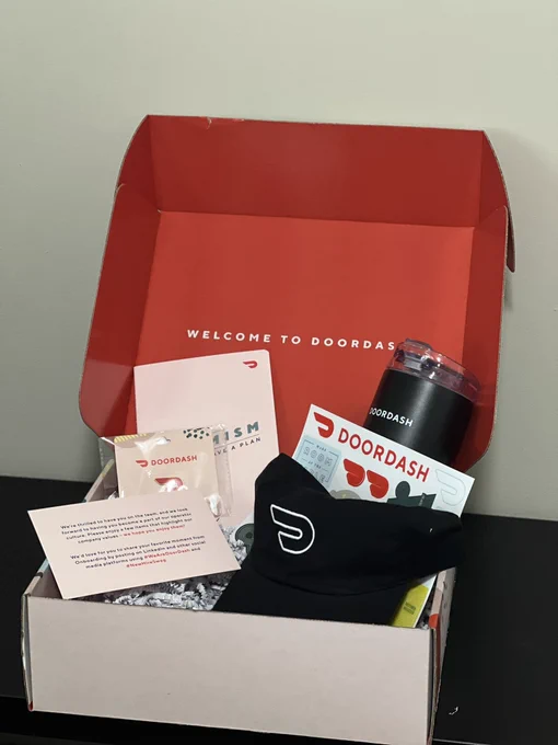 New hires onboarding swag. The package has sticker, a bottle, a cap, a small notebook, and a DoorDash pin.