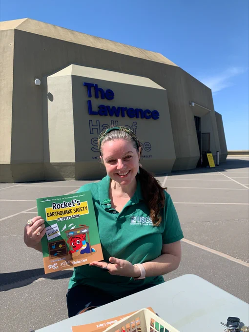 Dr. Sara McBride from USGS holds up a copy of Rocket's Earthquake Safety Activity Book.