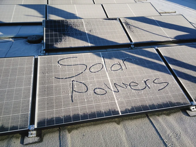 Solarmodul mit Schnee bedeckt
Im Schnee ist zu lesen "Solar Powers"