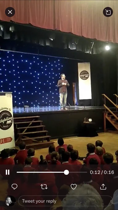 Sean mid story on stage in front of school pupils