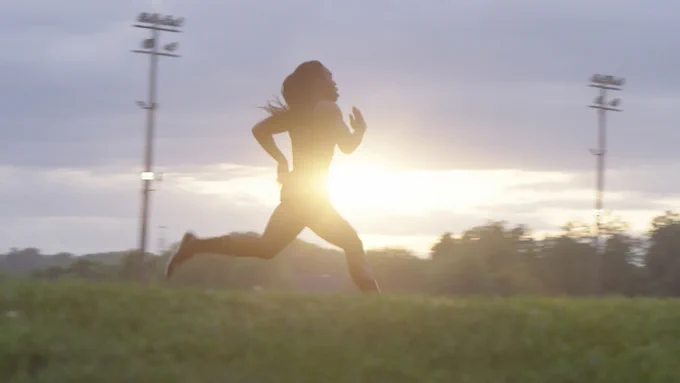 Andraya runs with the sun behind her.