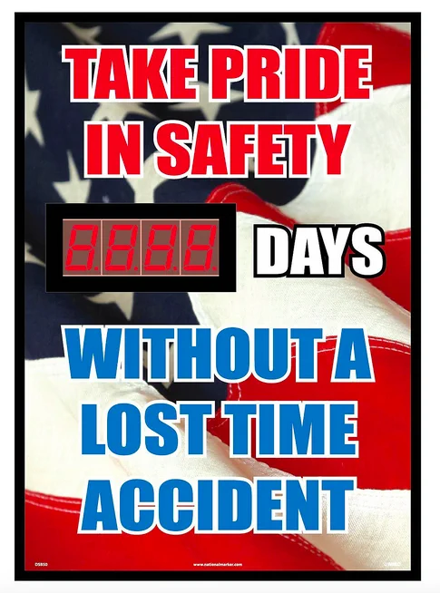 A sign that says "Take Pride in Safety. 0000 Days without a lost time accident. The background is an American flag, and the text is in red, white, and blue. The 0000 is an electronic display that can count up days as they pass.