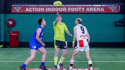 Two players and an umpire about todo a tip off to start play at an AFL Blind game.