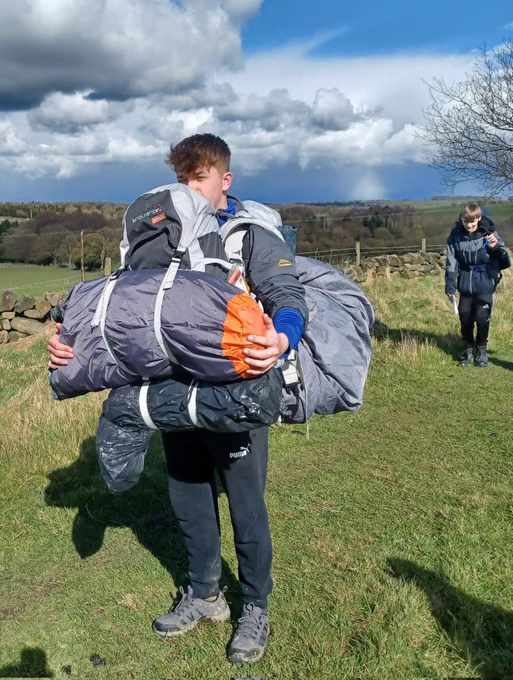 One cadet, two large rucksacks, maximum effort cresting a hill