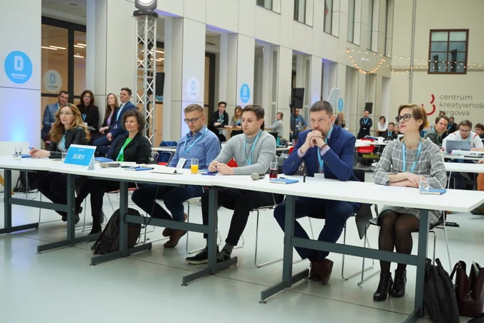 Na zdjęciu sześć osób, jury przy stole.