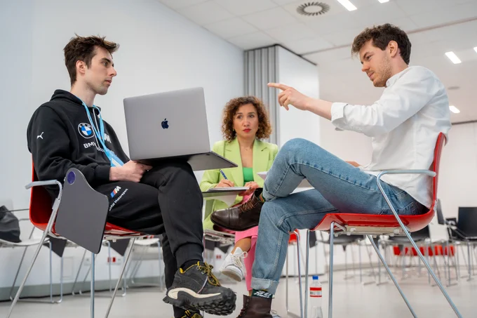 Na zdjęciu trzy osoby - Magdalena Petryniak prowadząca Datathon #OtwarteDane oraz dwóch uczestników.