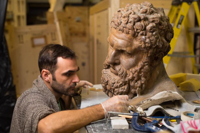 A person working on a model of Hercules