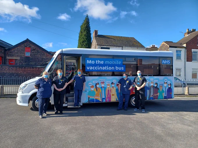 Clinicians stood outside the mobile vaccine bus,