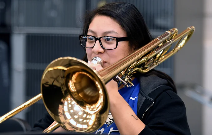 student playing horn in music class