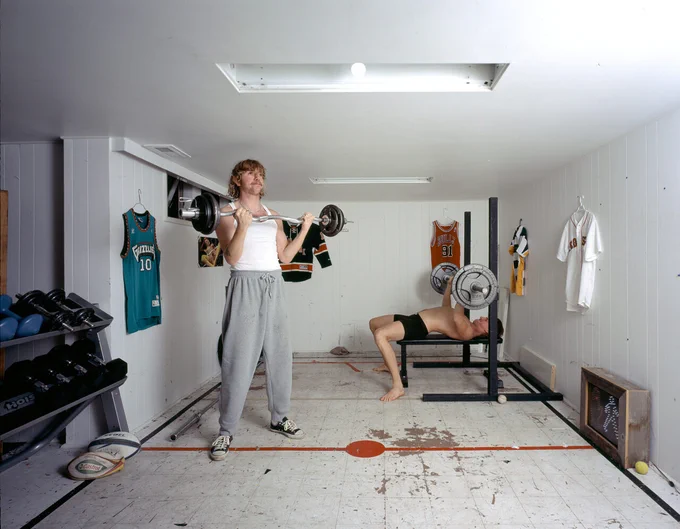 Photo of two people working out in a home gym.