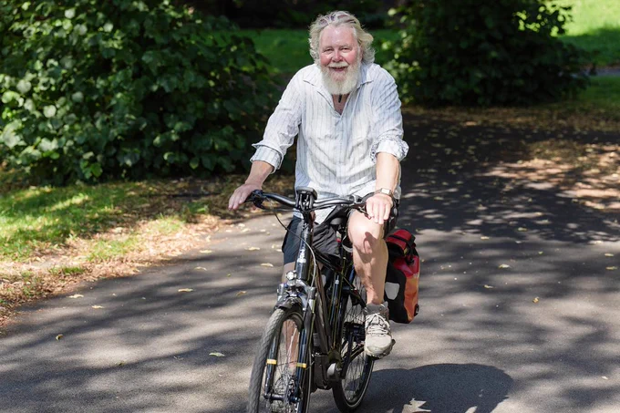 Man cycling in park with panniers