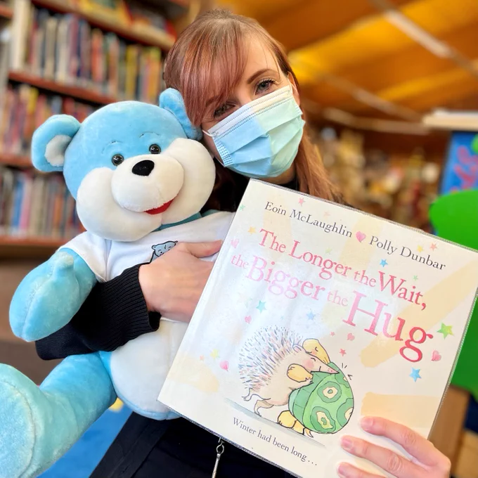 female member of staff holding a book
