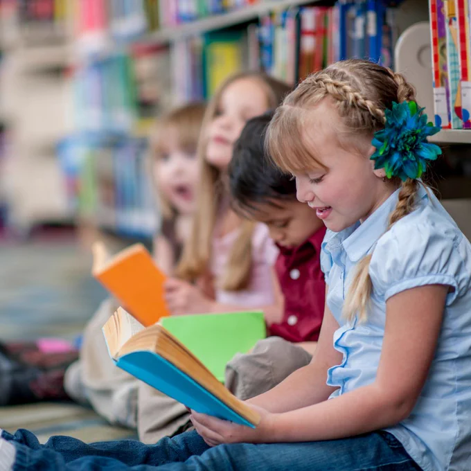 children reading in library shelves