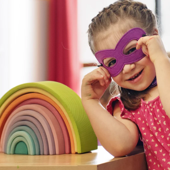 Child with wooden rainbow