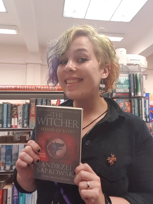 Member of staff holding a Witcher Book