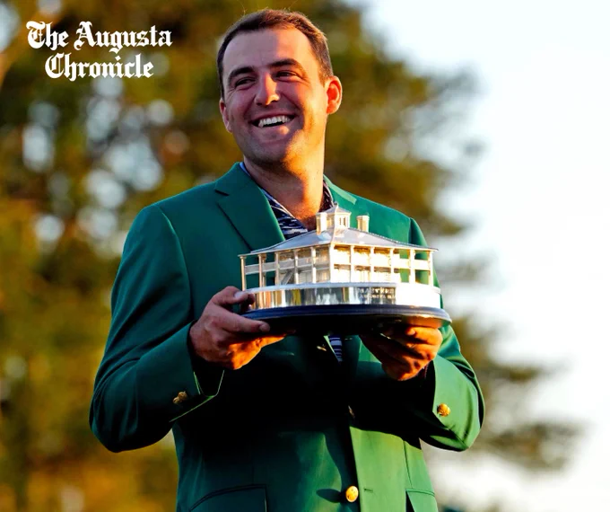 Scottie Scheffler smiling as he holds the Masters trophy.