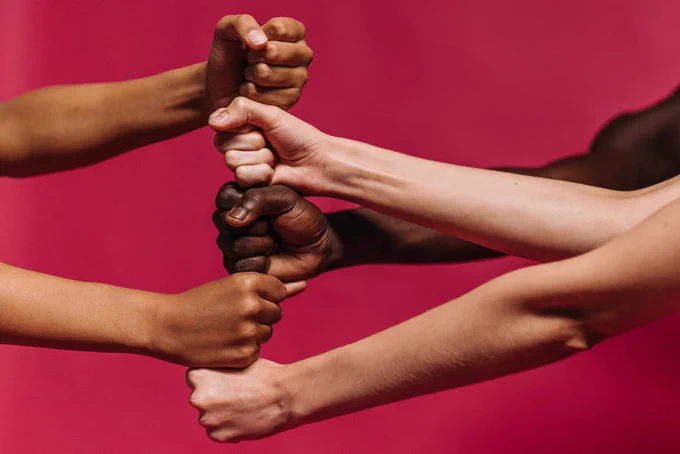 a close up 5 fists stacked up vertically in varying skin tones to signify diversity