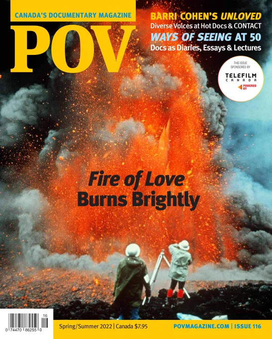 Magazine cover with a photo of two people in white hats photographing a volcanic explosion. There is lots of smoke, fire, ash, and lava.