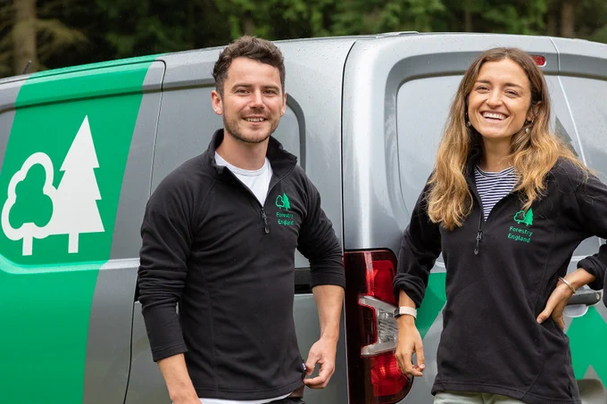 Forestry England staff standing beside a forestry van.
