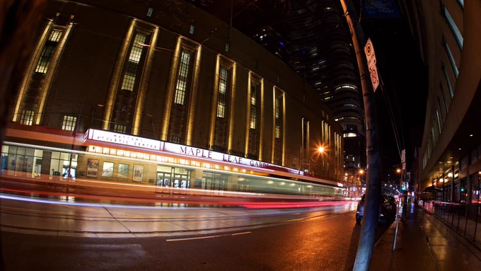 A streetcar drives by the exterior of the Mattamy Athletic Centre (formerly Maple Leaf Gardens)